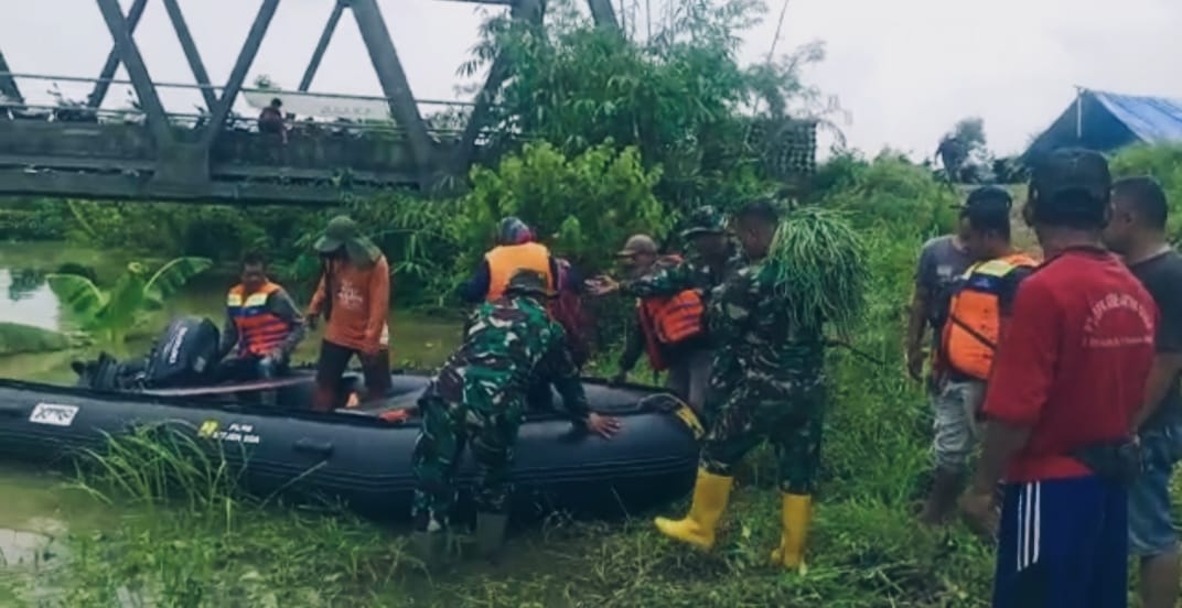 POLRI-TNI saat membantu warga menyeberangi luapan air dari bendungan yang menggenangi jalan penghubung