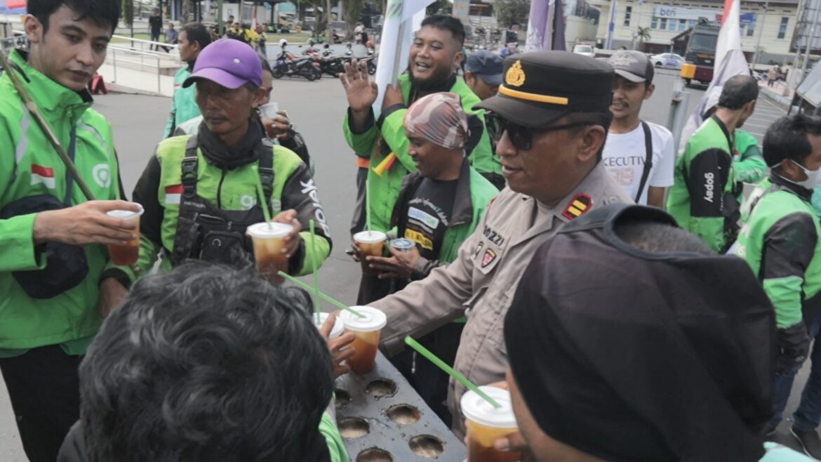 Humanis Polisi Kawal Aksi Damai Driver Ojol di Jember Sambil Berbagi Minuman Dingin
